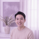 A smiling young adult of East Asian descent, looking at the camera with a friendly expression.